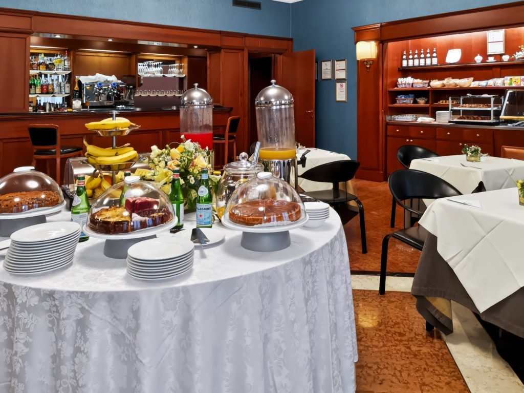 Buffet della colazione con torte, frutta e succhi davanti all'American bar dell'Hotel Luna
