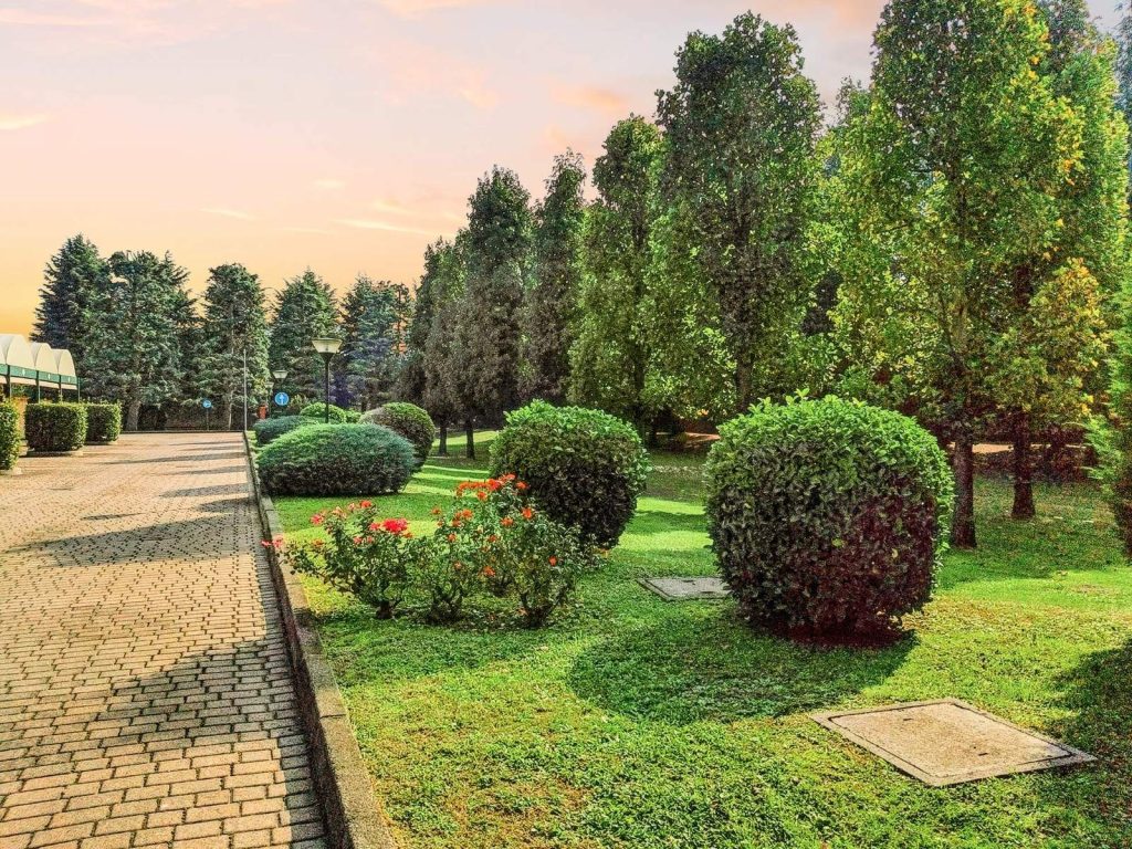Il giardino dell'Hotel Motel Luna a Novegro di Segrate, con alberi, siepi e vialetto