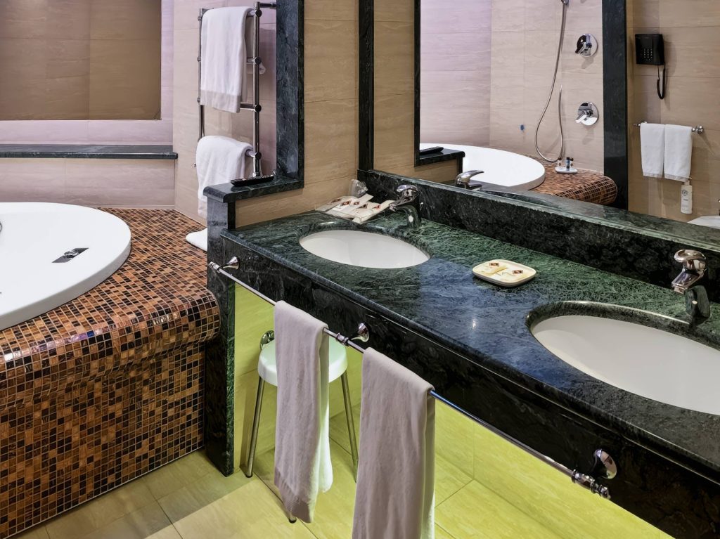 Bagno della Royal Suite con doppio lavabo in marmo verde e vasca idromassaggio