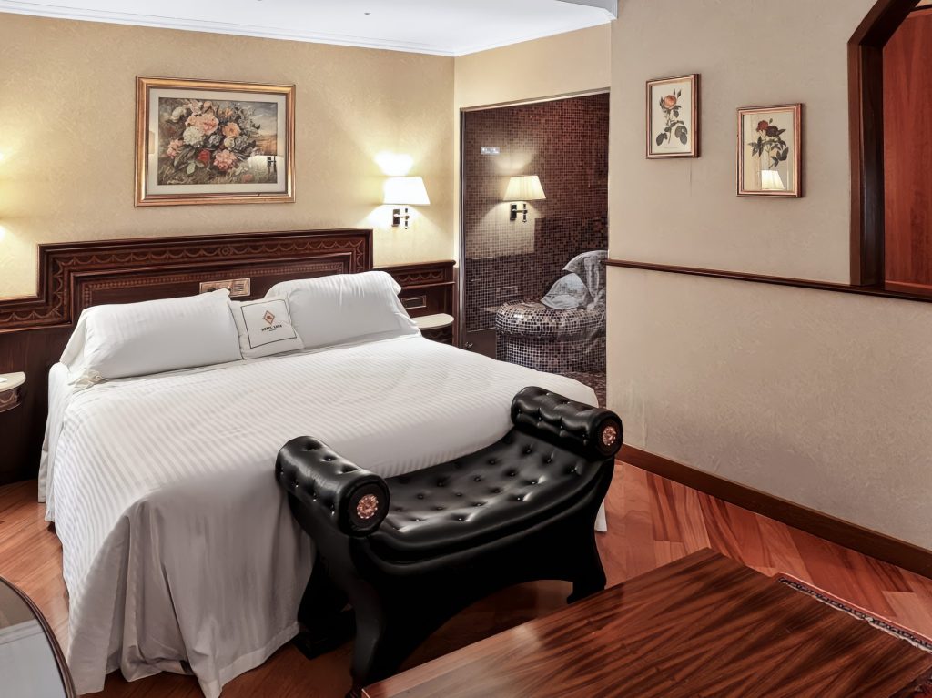 Letto matrimoniale della Royal Suite con panca in pelle, Hotel Motel Luna