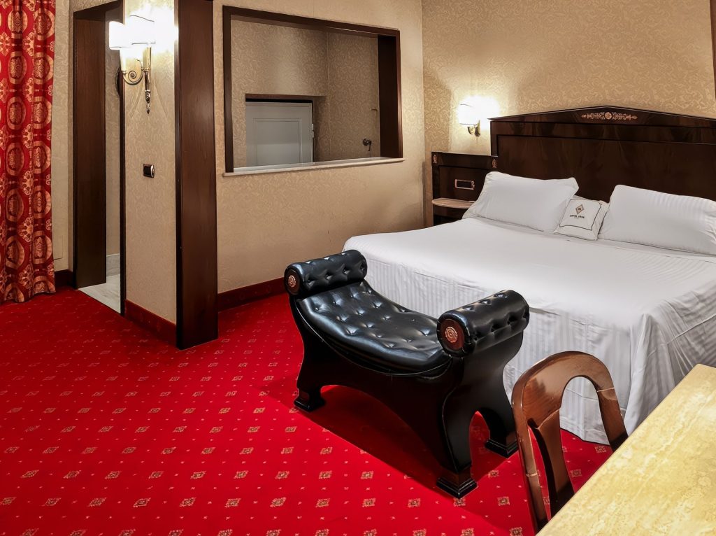 Suite Deluxe con letto matrimoniale, panca in pelle e moquette rossa, Hotel Motel Luna vicino a Linate