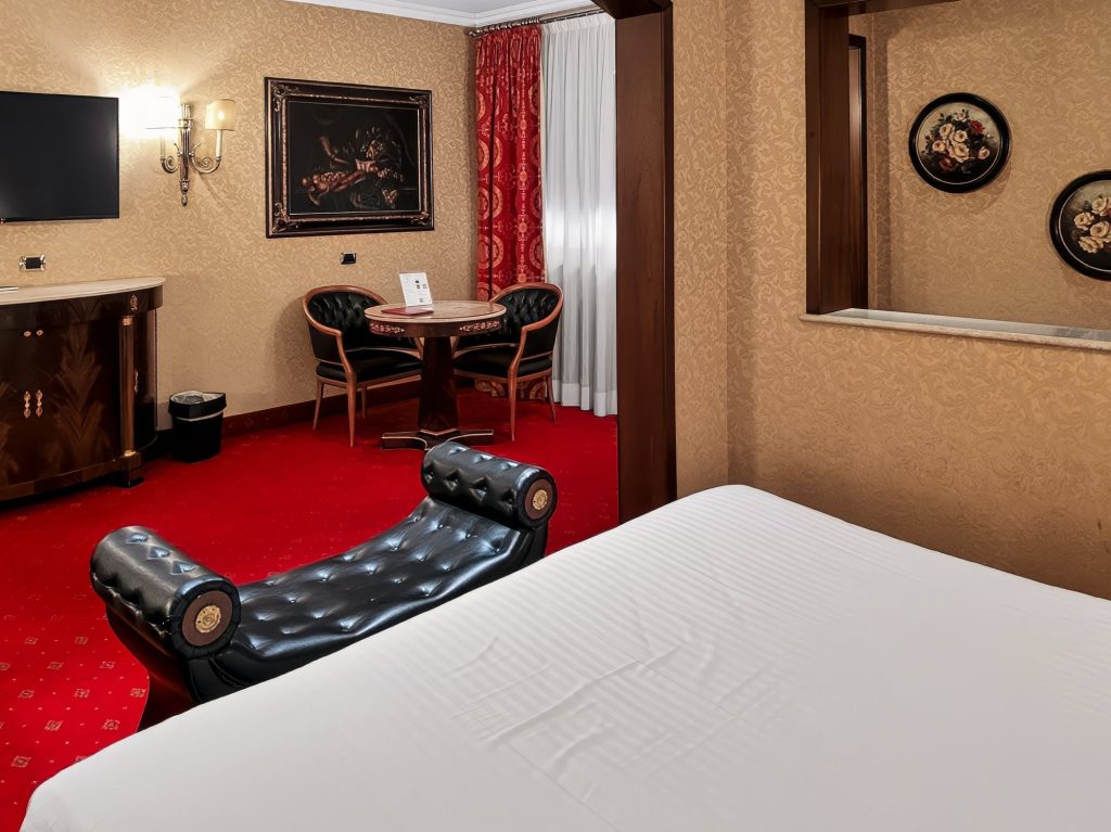 Salottino della Suite Deluxe con tavolino, poltrone e TV