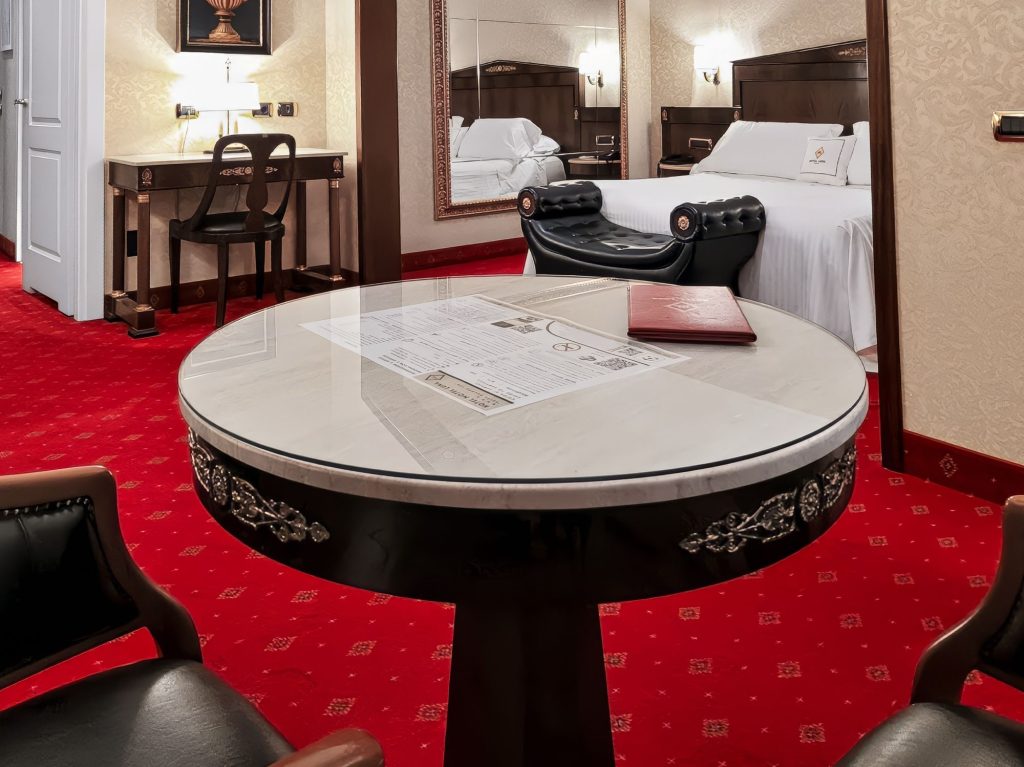 Tavolino in marmo, scrivania e letto matrimoniale nella Suite Deluxe