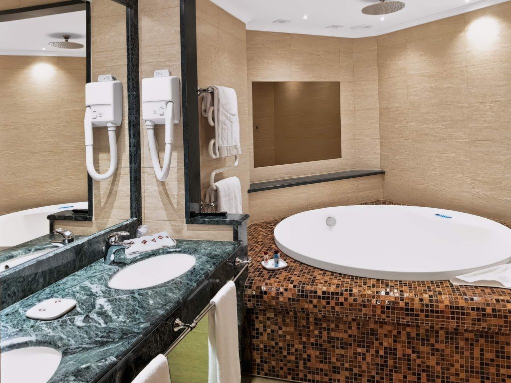 Bagno in marmo con vasca idromassaggio rotonda nella Suite Deluxe