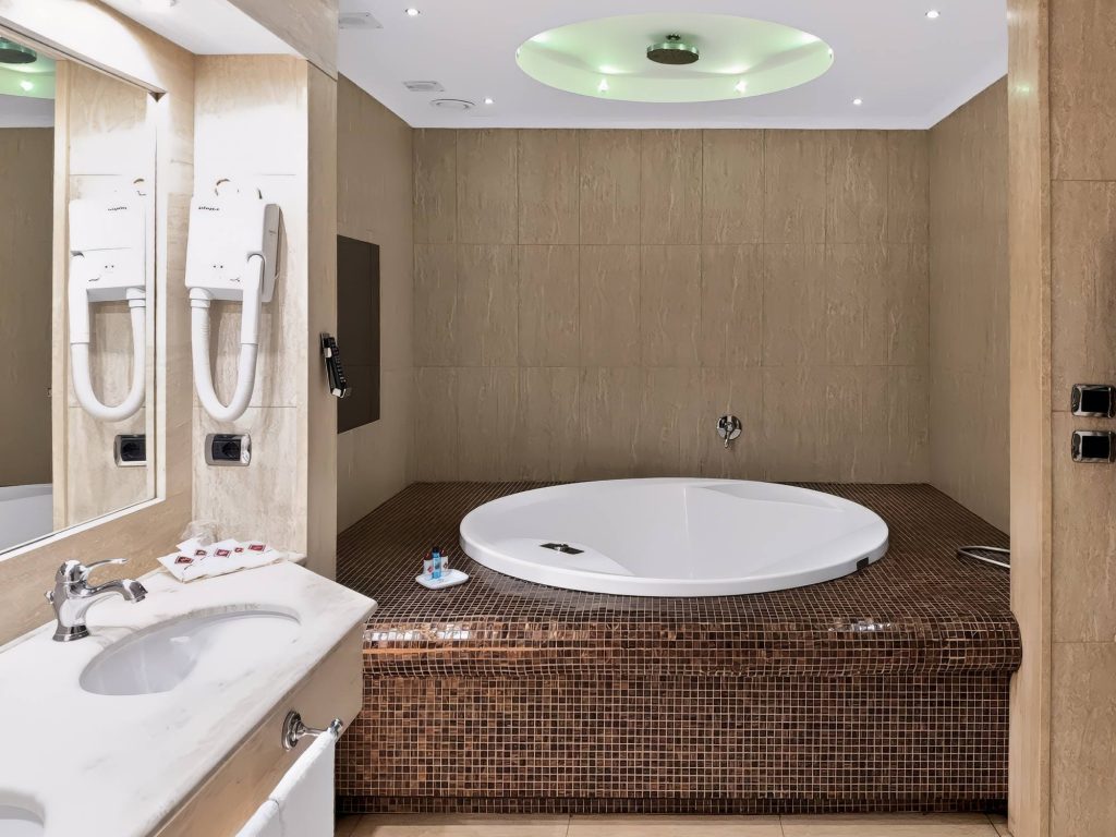 Vasca idromassaggio rotonda in mosaico con cromoterapia nella Suite Deluxe, Hotel Motel Luna